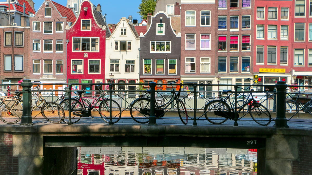 Amsterdam — kanałowe kamienice, rower na moście i wieczorne światło nad wodą