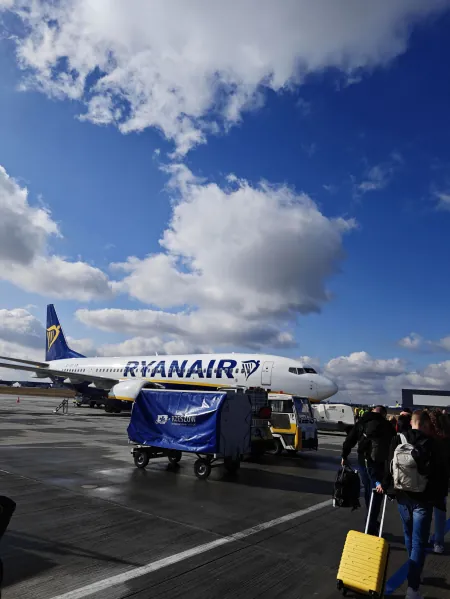 Samolot Ryanair na płycie polskiego lotniska, podróżni idą do wejścia